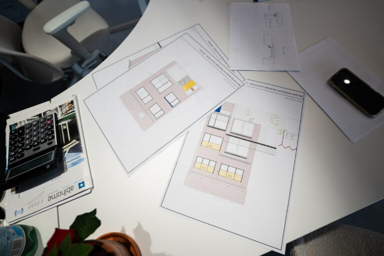 Plans d'élévation et documentation Abihome étalés sur un bureau d'étude