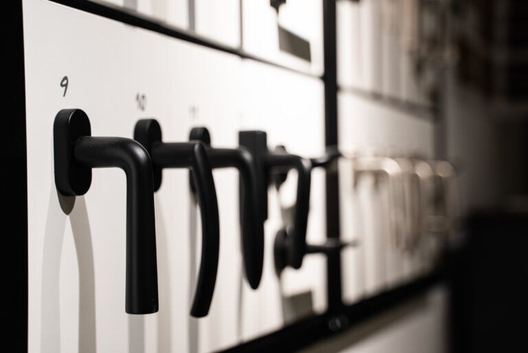 Poignées de fenêtre noires présentées sur un panneau d'exposition en showroom