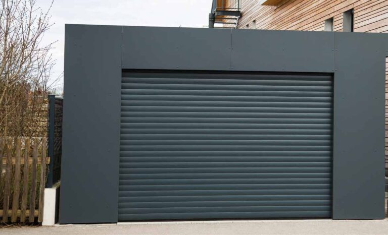 Porte de garage enroulable à lames gris anthracite, encadrement en aluminium, entrée de garage extérieure.