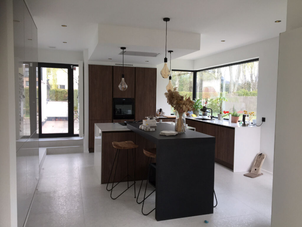Cuisine ouverte avec baie vitrée d'angle en aluminium et porte-fenêtre, à Herent