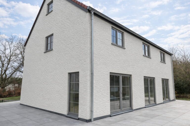 Maison en briques peintes en blanc avec châssis et portes-fenêtres PVC gris, près de Louvain